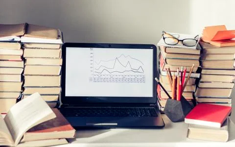Laptop, stack of books, notebooks and pencils on white table, education offic Stock Photos