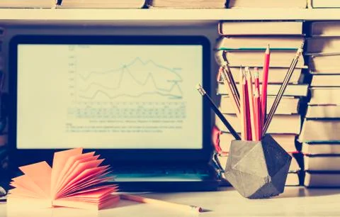 Laptop, stack of books, notebooks and pencils on white table, education offic Foto stock