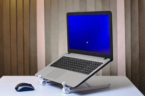 Laptop is started and installed on cooling stand. Stock Photos
