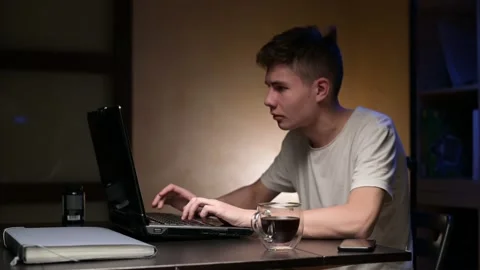 Laptop starts to smoke while working. guy in panic pours coffee on the keyboard Stock Footage 163997890