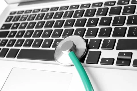 Laptop with stethoscope, closeup view. Computer repair Stock Photos