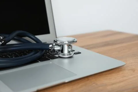 Laptop with stethoscope on table, closeup. Computer repair Stock Photos