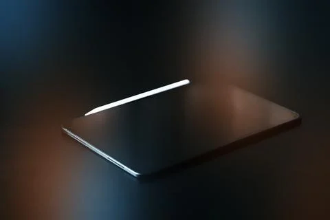 Laptop with a stylus on a dark surface in a workspace setting Stock Photos