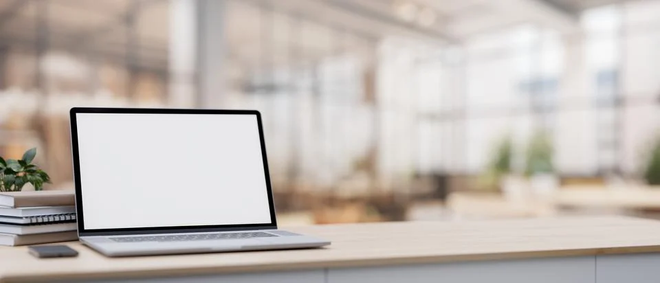 A laptop on a table with a blurred background of a spacious luxurious cafe .. Stock Illustration