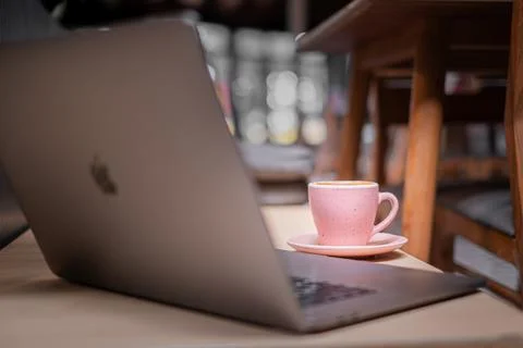 A laptop on the table with a cup of coffee. Stock Photos