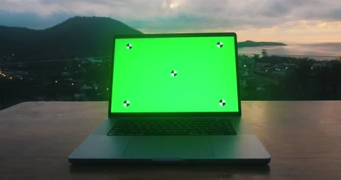 Laptop on a table with a green background mockup against the backdrop of Stock Footage 238904285