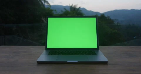 Laptop on a table with a green screen mockup outdoors on background of tropical Stock Footage 239836739