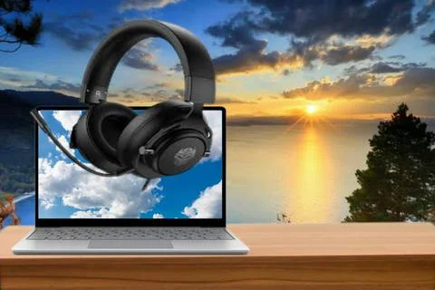 Laptop on the table with a sunset view accompanied by a headset to relax Stock Illustration