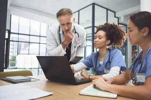 Laptop, thinking and training students with doctor in hospital for healthca.. Stock Photos