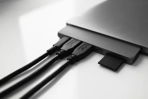 Laptop with USB Type-C adapter with pluged USB cables and SD card. The USB Stock Photos
