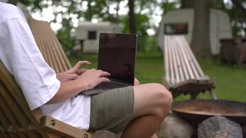Laptop user enjoys outdoor setting near campsite Vídeo Stock 342586597