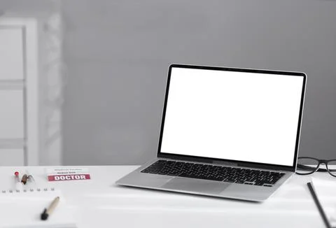Laptop on white table with white blank screen and copy space. Stock Photos