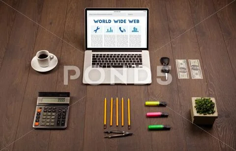 Laptop on wooden desk with office suplies Stock Photos