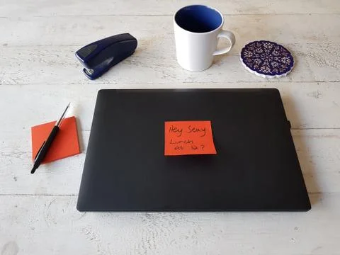 Laptop on wooden table and red post-it note Stock Photos
