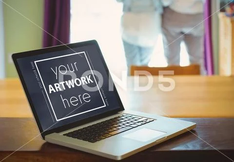 Laptop on wooden table template PSD Template