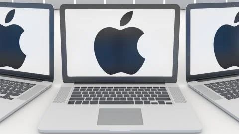 Laptops with Apple Inc. logo on the screen. Modern office building entrance Stock Illustration