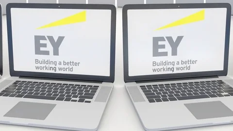 Laptops with Ernst & Young logo on the screen. Computer technology conceptual Stock Footage