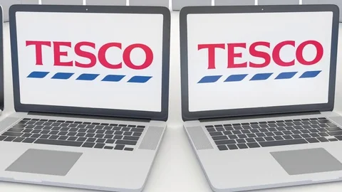 Laptops with Tesco logo on the screen. Computer technology conceptual editorial Stock Footage