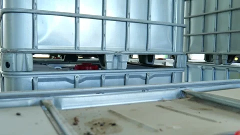 Large 1000 liter square IBC chemical storage tank placed inside an industrial wa Vídeo Stock 347795530