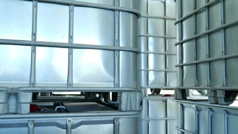 Large 1000 liter square IBC chemical storage tank placed inside an industrial wa Видео 347795562