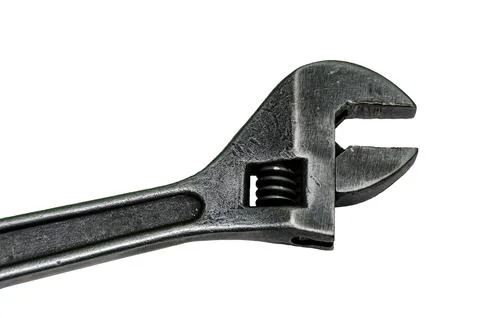 Large adjustable wrench on a white background. Insulated object. Old worn too Stock Photos