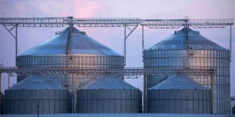 Large agricultural grain processing plant at sunset Stock Photos