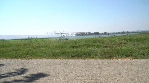 Large agricultural irrigation machine working and boy cycling  Stock Footage 140093099