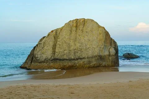 A large alone rock on a sandy beach Stock Photos