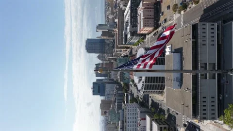 Large American flag flying on flagpole in foreground with dense downtown Stockbeeldmateriaal 336334721