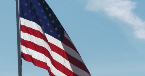 Large American Flag Flying in the Wind with Blue Skies, 4K Stock Footage