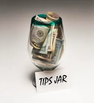 Large amount bills in tips jar Stock Photos