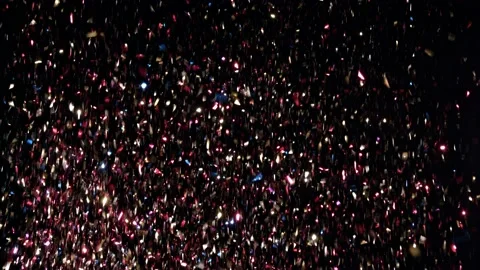 Large amount of confetti falling against black background shot in studio Stock-Footage 142393930