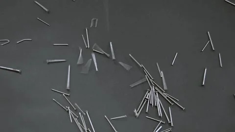 Large amount of different types of metallic nails falling on a black backgrou Stock Footage 133377039