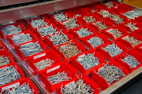 Large amount of red trays with assorted screws Stock Photos