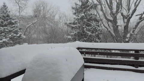 Large amount of snow landing on back patio during storm 4k Stock Footage 332527950