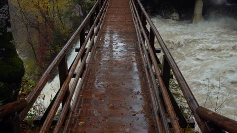 A large amount of water flowing under the wooden bridge Stock Footage 255039894