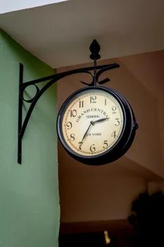 Large analog public clock with white dial and big numbers hanging from wall Foto stock