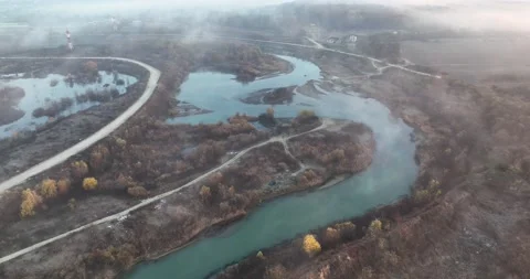 Large and beautiful rainforest river surrounded by fog, road, and wide land Stock Footage 198357324