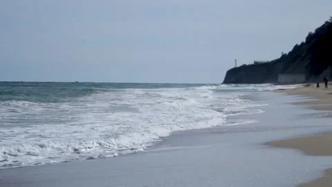 Large and heavy waves wash up on the sandy shore. Foamy waves break on the shore Stock Footage 315178580