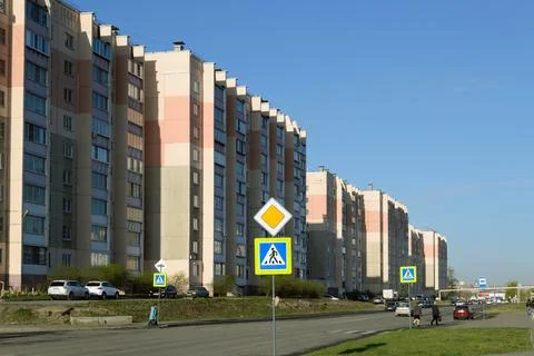 Large and identical multi-storey residential buildings next to the road Stock Photos