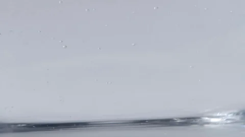 Large and small bubbles forming as clear liquid is poured Stock Footage 114085443