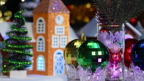 Large and small Christmas balls and branches rotate against decorated houses Stock Footage 288096062