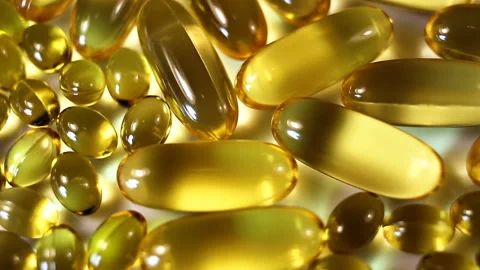 Large and small oval light yellow transparent contrasting yellow capsules move f Stock Footage 145107574