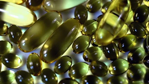 Large and small oval transparent contrasting yellow capsules move from left to r Stock Footage 145107659