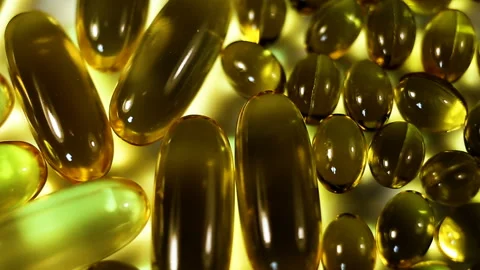 Large and small oval yellow-green capsules of fat-soluble vitamins, Close-up, ri Stock Footage 145108165