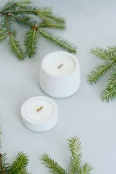Large and Small Soy Scented Candle on Light Background Among Christmas Tree B Stock Photos