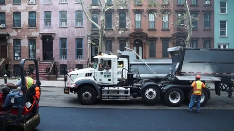 Large and small steam roller trucks paving a residential urban road Stock Footage 80206601