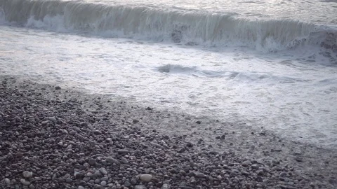 Large and strong waves of the sea break on the rocky beach at sunset Stock Footage 122852746