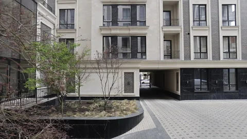 A large apartment building with many windows and trees in front Stock Footage 307934368