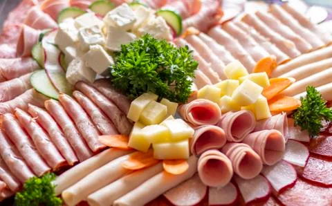 Large appetizer plate filled with slices of meat, bacon, salami, cheese, cherry  Stock Photos